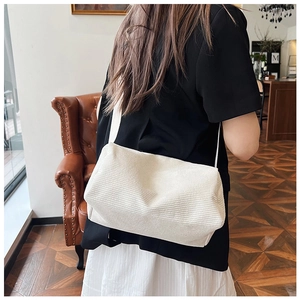 Close-up of white corduroy crossbody bag texture and stylish shoulder strap detail