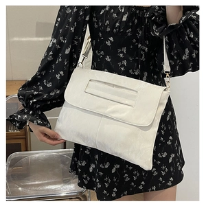 White pleated PU leather envelope bag with gold hardware shown on a floral dress