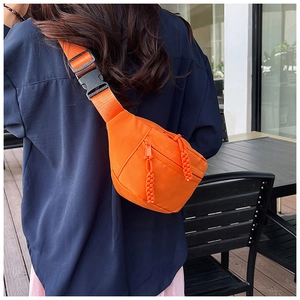 Détail d'un sac de poitrine en nylon orange vif avec sangle réglable sur un mannequin