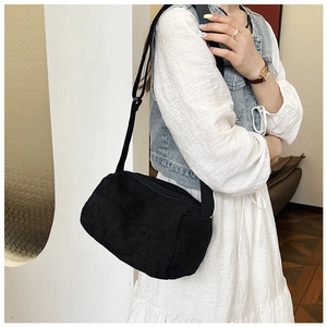 Detail of black corduroy crossbody bag with soft texture and adjustable strap