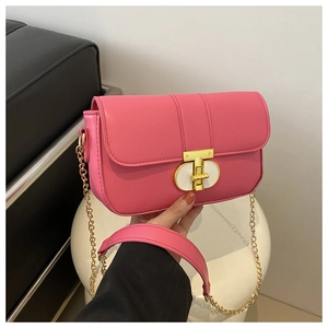 Close-up of rose pink leather handbag featuring a stylish gold T-shaped twist lock closure