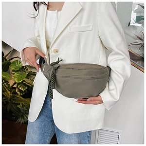 Détail du sac de poitrine en nylon vert olive avec texture imperméable et fermeture éclair