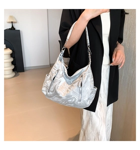 Detail of silver marble textured shoulder bag with dual metallic zippers and wide strap