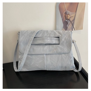 Detailed close-up of light blue envelope bag with unique paper-like wrinkled texture