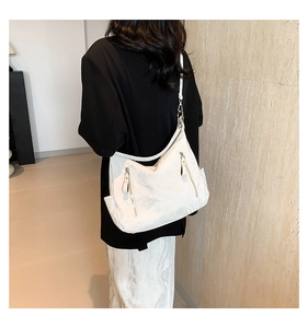 Detail view of white marble pattern shoulder bag with decorative vertical zippers