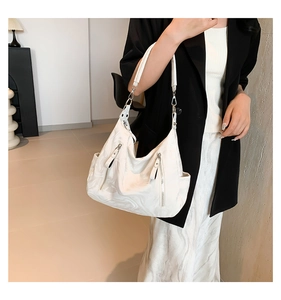 Detail showing marble texture handbag with silver zippers and vertical metal hardware