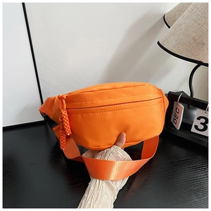 Détail du sac de poitrine en nylon orange avec tirette tissée et sangle réglable