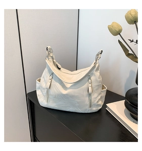 Detail of off-white marble pattern tote bag featuring functional silver zippers and side pockets