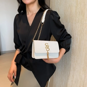 Minimalist white rectangular shoulder bag with golden S-logo and fringe tassel details