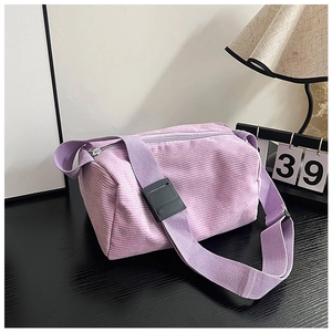 Detailed macro view of purple corduroy fabric texture on a cylinder crossbody bag