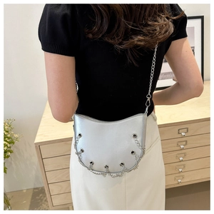 Detail of silver crescent bag with metal chain accents and eyelet hardware craftsmanship