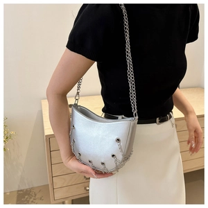 Detail of silver metallic crescent bag featuring hole-punched chain edge and shoulder strap