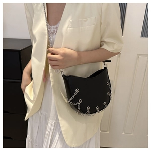 Close-up of black half-moon bag featuring silver metal chain fringe and sleek PU leather