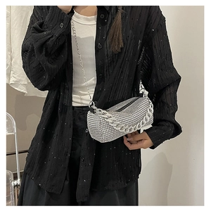 Detail of silver rhinestone cylinder bag featuring decorative thick metal chains