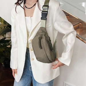 Sac de poitrine décontracté vert olive avec bandoulière en nylon porté par un mannequin