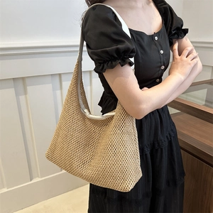 Retro woven tote bag with white leather straps shown on shoulder in a cozy interior setting