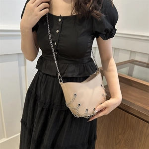 Minimalist beige semi-circular crossbody bag with silver chains and metallic eyelets