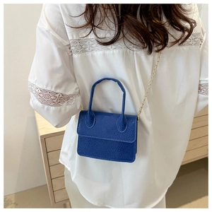 Close-up of blue mini crossbody bag with litchi texture PU leather and gold chain