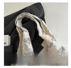 Close-up of soft jacquard tote bag with grey butterfly patterns and feather-like texture