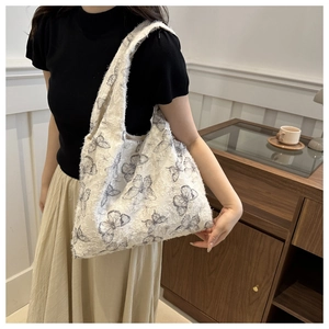 Detailed texture of white woven tote bag featuring blue butterfly jacquard patterns