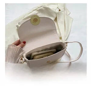Interior view of beige saddle bag showing storage capacity and striped fabric lining