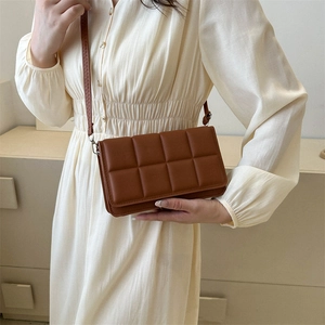 Brown quilted crossbody bag with textured puff square pattern and elegant shoulder strap