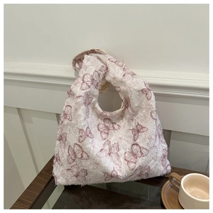Detail of floral butterfly jacquard fabric on a soft knit shoulder bag texture