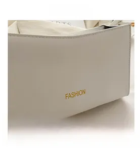 Gros plan d'un sac à main en cuir blanc avec texte FASHION doré et coutures détaillées
