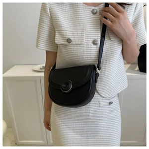 Detail view of black leather half-moon crossbody bag with elegant metal buckle