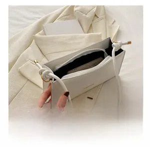 Détail du sac à épaule rectangulaire blanc avec logo FASHION et poche intérieure zippée