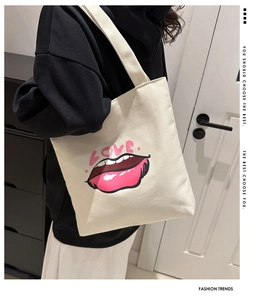 Dettaglio della borsa tote in tela con stampa labbra rosa, testo LOVE e spalline larghe