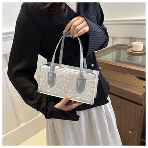 Detail of white crocodile texture leather handbag with light blue handle contrast