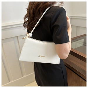 Détail du sac bandoulière en cuir blanc avec texte FASHION doré et bandoulière à nœuds