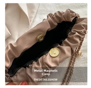 Close-up of the secure magnetic gold buckle closure on a beige quilted leather bag