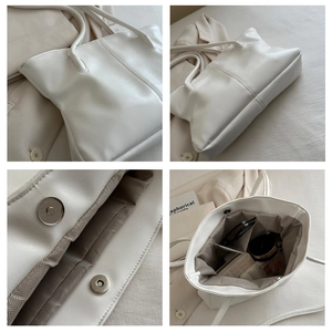 Detail view of large beige tote bag showing magnetic closure and herringbone fabric lining