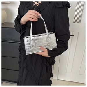 Detailed view of silver rectangular handbag with premium crocodile pattern texture