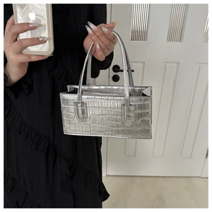 Detailed view of silver crocodile pattern square handbag with sturdy double handles