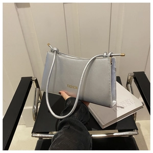 Détail du sac argenté métallisé avec lettrage fashion doré et bandoulière à nœud élégant