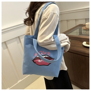 Dettaglio della borsa tote in tela azzurra con motivo labbra e stampa artistica LOVE