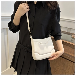 Borsa a tracolla crema stile francese con trama ondulata indossata da una modella