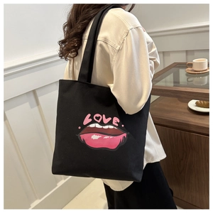 Borsa tote in tela nera con stampa di labbra rosa e scritta LOVE indossata da modella