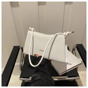 Détail du sac blanc en similicuir avec texte doré et bandoulière en corde tressée