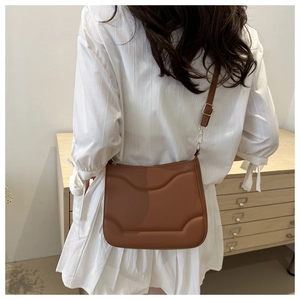 Dettaglio della borsa in pelle marrone con trama geometrica e chiusure dorate eleganti