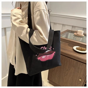 Dettaglio della borsa tote in tela nera con stampa labbra rosa e design LOVE sulla spalla