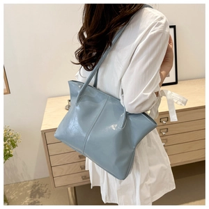 Lifestyle shot of light blue glossy tote bag with spacious interior for daily commute