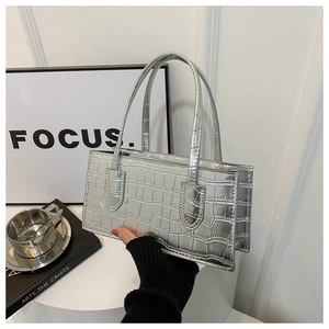 Detail of silver rectangular handbag with crocodile texture and double top handles