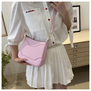 Dettaglio borsa a tracolla rosa in PU con trama a rilievo su outfit casual estivo