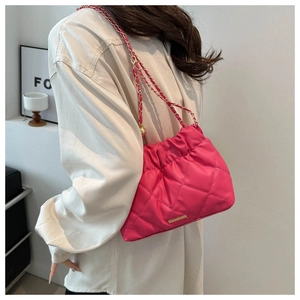 Detail of hot pink quilted shoulder bag with gold chain strap and elegant hardware