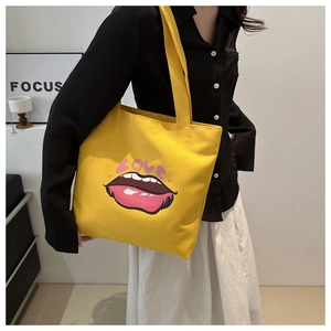 Dettaglio della borsa tote in tela gialla con scritta LOVE rosa e stampa di labbra rosse