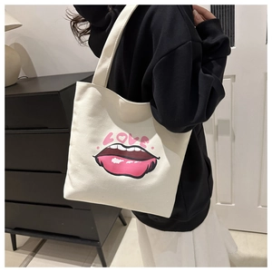 Dettaglio laterale della borsa tote in tela beige con stampa labbra rosa e LOVE